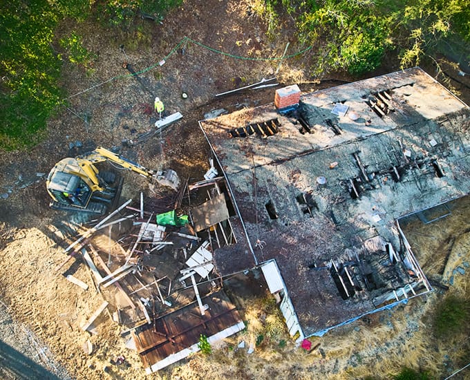 A machine operator demolishing a home.