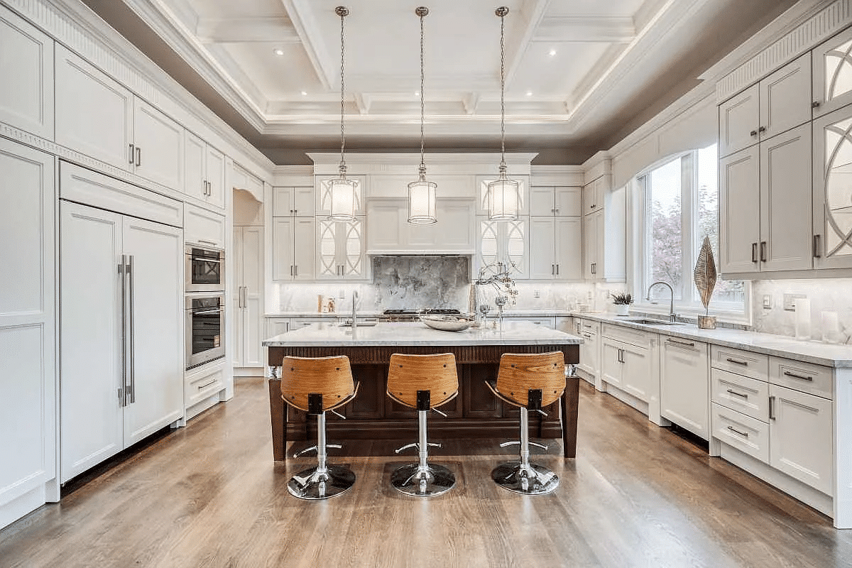 All white luxury kitchen with natural wood barstools, marble island and backsplash.