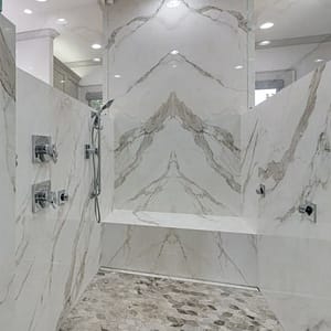 Lovely Allenhurst bathroom featuring eyecatching Calacatta marble in an oversized shower.